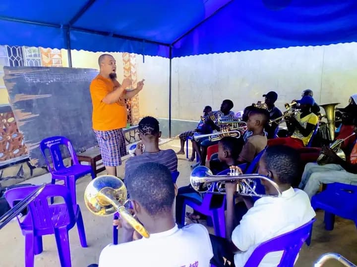 Volunteer conducting music theory class at a chalkboard